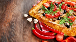 عکس با کیفیت پیتزا روی میز چوبی